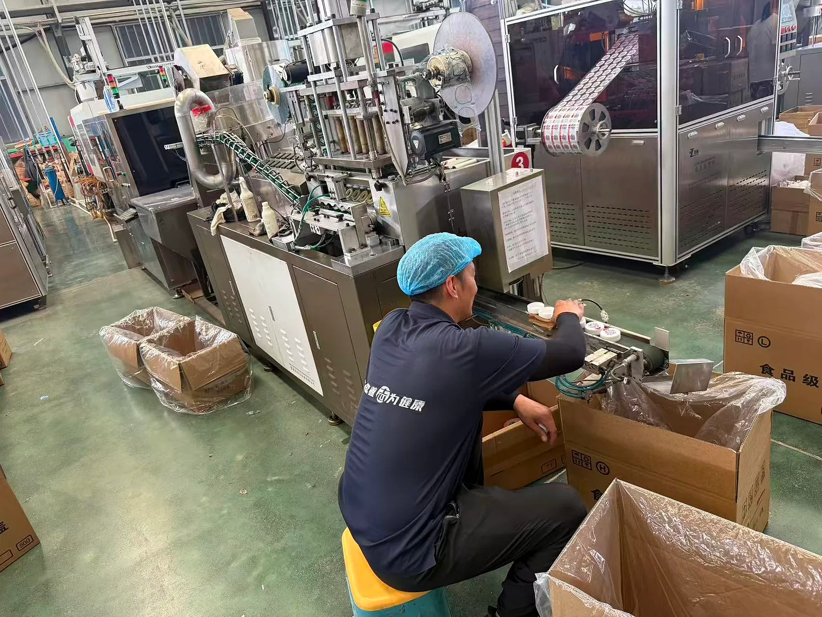 Operator working at an automated cap forming and slitting machine