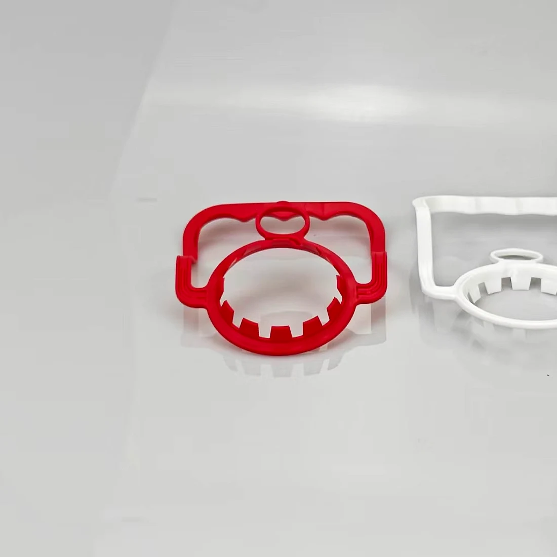 Red and white plastic carry handles for barrelled water necks